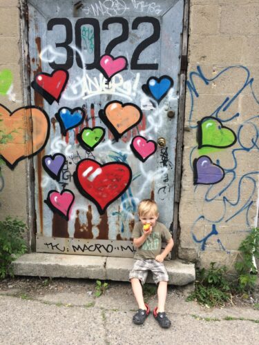 Natalie's son in front of a mural