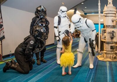 Stormtroopers high-five a girl at Comicon